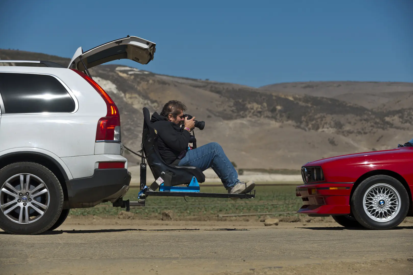 A man sitting on the back of his car