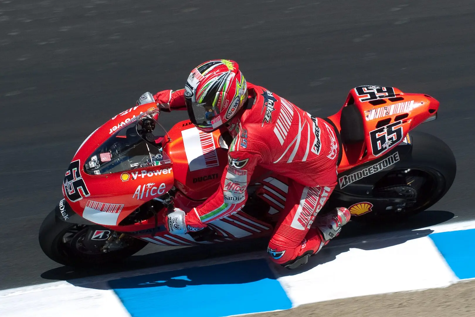 A man riding on the back of a red motorcycle.