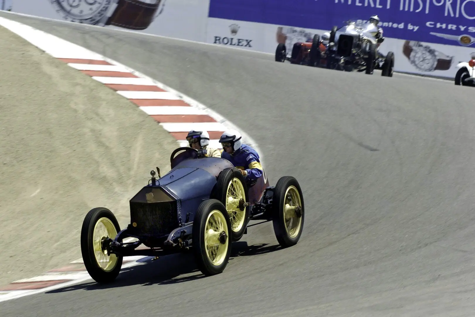 A vintage race car driving down the track.