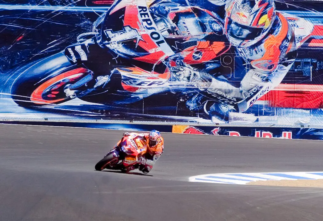 A person on a motorcycle in front of a mural.